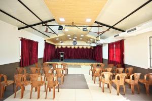 DharmastalaHotel Rays Inn Boarding & Lodging的舞台前的带椅子和舞台的房间