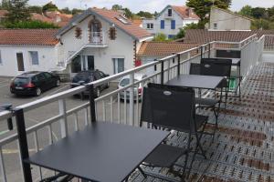 a group of tables and chairs on a balcony at Appart : houedic : plein sud, front de mer in La Bernerie-en-Retz +3 photos