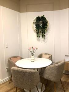 biała jadalnia z białym stołem i krzesłami w obiekcie Sands Sopot Apartments 1a w mieście Sopot