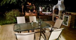 a glass table and white chairs on a patio at Villa Prima Wellness Badacsony in Badacsonytomaj