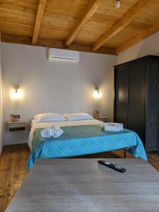Fattoria Il Laghetto في لاميزيا تيرمي: غرفة نوم مع سرير مع ريموت كنترول على الأرض