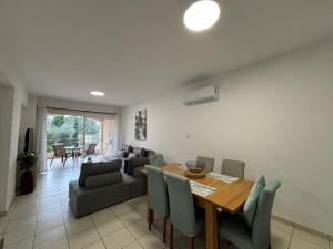 comedor y sala de estar con mesa y sillas en Cozy Apartment in Paphos Beautiful Complex, en Pafos