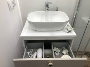 łazienka z białą umywalką w szafce w obiekcie Sands Sopot Apartments 1a w mieście Sopot