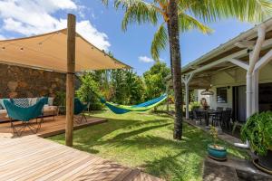 a backyard with a hammock and a house at 3 Bedroom Villa with pool and garden in Grand Baie in Grand-Baie