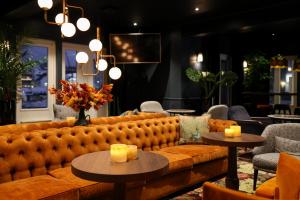 a couch in a room with tables and chairs at Quality Hotel Florø in Florø