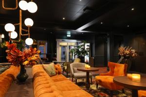 a lobby with a couch and tables and chairs at Quality Hotel Florø in Florø