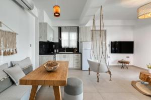 a kitchen and living room with a wooden table at WHITE ROCK VILLAS LEFKADA in Lygia