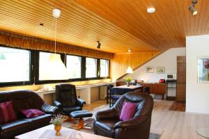 ein Wohnzimmer mit Ledersesseln und einem Tisch in der Unterkunft Ferienwohnung Helene in Olsberg