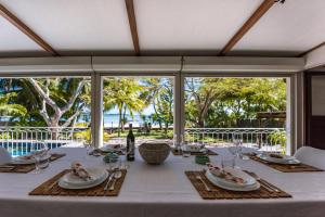 uma mesa de jantar com uma toalha de mesa branca e vista para o oceano em Quaint 4-bedroom Beach Villa in a fishing village em Grand Gaube