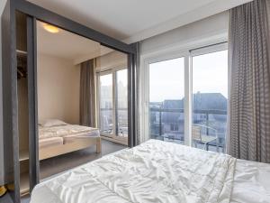 1 dormitorio con cama y ventana grande en Zandroos 3 bedrooms on floor 3, en Middelkerke