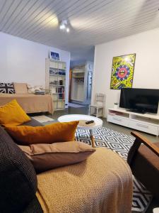 a living room with a couch and a flat screen tv at Päätyhuoneisto: Nariseva puulattia! in Pori