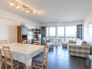 comedor y sala de estar con mesa y sillas en Zandroos 3 bedrooms on floor 3, en Middelkerke