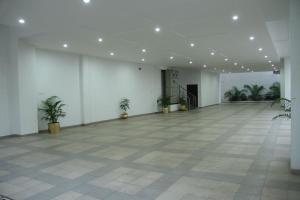 HOTEL THE SENTOSA في راجكوت: غرفة فارغة كبيرة مع نباتات الفخار فيها