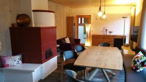 a living room with a wooden table and a kitchen at Ferienhaus Casa Rosa - LienzOsttirol in Leisach
