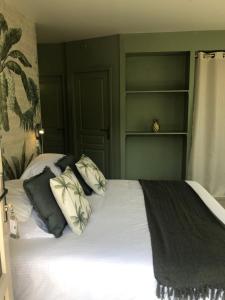 a bedroom with a bed with green walls and shelves at Logis Hôtels Troglododo in Azay-le-Rideau