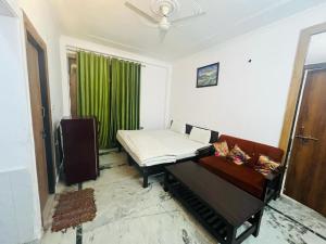a room with a bed and a couch and a window at Hotel Apollo - Near Apollo Hospital in New Delhi