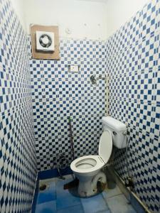 baño con aseo en una pared de azulejos azules y blancos en Hotel Apollo - Near Apollo Hospital, en Nueva Delhi