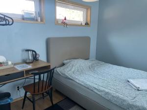 a bedroom with a bed and a desk and a chair at Cozy Blue Apartment in Vantaa