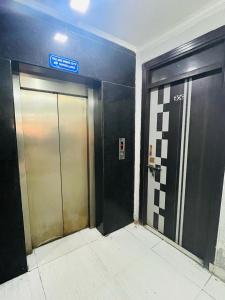 two elevator doors in a building with a sign on it at Hotel Apollo - Near Apollo Hospital in New Delhi