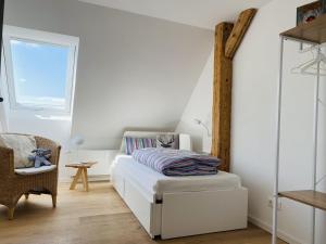 a bedroom with a bed and a chair and a window at Ferienwohnung Haus Alpenblick in Lenzkirch