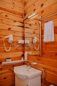 a bathroom with wooden walls and a toilet and a sink at The Regalia Resort in Mandrem