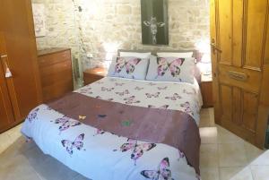 a bedroom with a bed with butterflies on it at Chocolate Box Cottage in Parzac