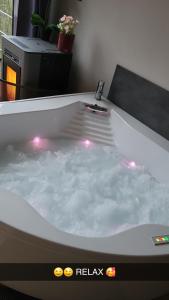 Beloeil的住宿－Ô Chalet，浴缸里装满水,里面装有灯