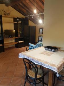 a dining room with a table and chairs and a television at La Mansarda di Didi in Capannori