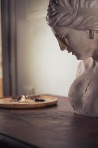 uma estátua de um homem sentado à mesa com um prato de comida em The Tuscany Rose em Pistoia