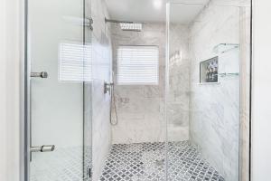 a bathroom with a shower with a glass door at Historic Culpeper Farmhouse in Culpeper