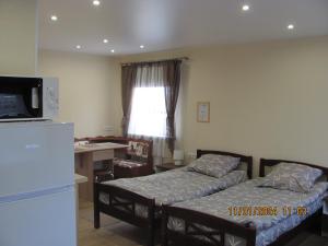 a room with two beds and a kitchen with a refrigerator at ziedu pasaule 2 in Krāslava