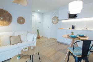 sala de estar con sofá blanco y mesa en Budget Beach Studio 23 en Sant Antoni de Calonge