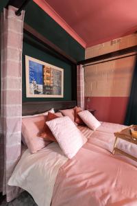 a bedroom with a large bed with pink and white pillows at Concetta Studio Apartments in Cospicua