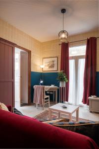 a living room with a table and red curtains at Concetta Studio Apartments in Cospicua