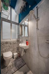 a bathroom with a shower and a toilet and a sink at Concetta Studio Apartments in Cospicua