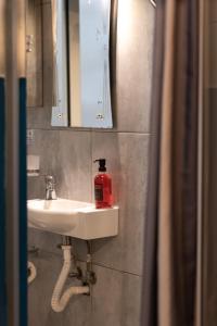 a bathroom with a sink with a red extinguisher on it at Concetta Studio Apartments in Cospicua