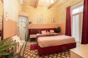 a bedroom with two beds and a shower at Concetta Studio Apartments by Holihomes in Cospicua