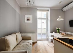 un soggiorno con divano e tavolo di Too-Good Apartments a Cracovia