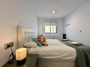 a white bedroom with a large bed and a window at Zarauz sea views. Águilas Costa Cálida. in Águilas