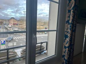 una ventana con vistas a un aparcamiento en Armor Hotel en Compiègne