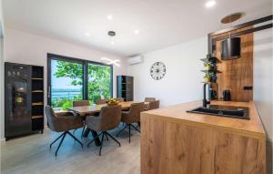 een keuken en eetkamer met een tafel en een klok bij Villa Royal Hill with pool in Šarić