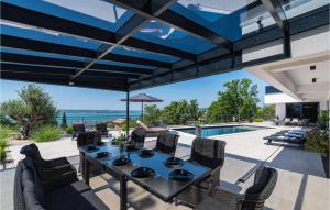 een terras met een tafel en stoelen en een zwembad bij Villa Royal Hill with pool in Šarić