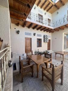 a dining room with a wooden table and benches at Asia Central Boutique in Bukhara