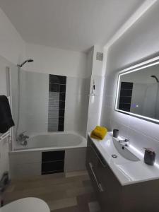 uma casa de banho com uma banheira, um lavatório e um WC. em Studio "La Parenthèse", à 50 mètres de la plage em Saint-Quay-Portrieux
