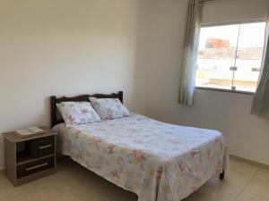 een slaapkamer met een bed en een raam bij Casa na praia d’Ulé in Guarapari