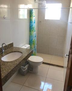 uma casa de banho com um WC, um lavatório e um chuveiro em Casa na praia d’Ulé em Guarapari