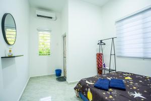 - une chambre avec un lit, un miroir et une fenêtre dans l'établissement De Sungai Langkawi Guesthouse, à Pantai Cenang