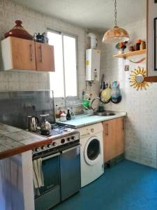 een keuken met een fornuis en een wasmachine bij Homenfun Madrid Villaverde Bajo in Madrid