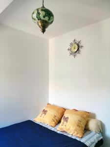 een slaapkamer met een bed met kussens en een kroonluchter bij Homenfun Madrid Villaverde Bajo in Madrid