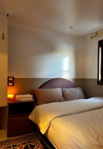 1 dormitorio con 1 cama y 1 mesa con lámpara en Houseboat Hotel and Nile Cruises Zainoba en Nag` el-Ramla